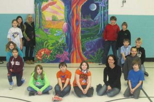 Professional mural artist Maureen Walton of Belleville with grade 5/6 HPS teacher Kathryn Sawdon and some of the students who helped create an Aboriginal-themed mural that they hope to see installed at the new school in Sharbot Lake.